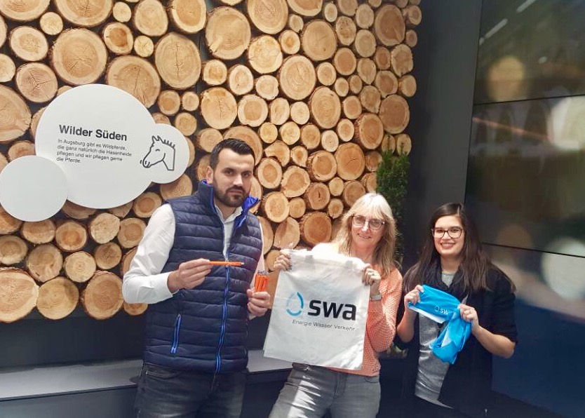 Von den Augsburger Stadtwerken bekommt Frau Lang 250 Kugelschreiber und 500 Schals überreicht.